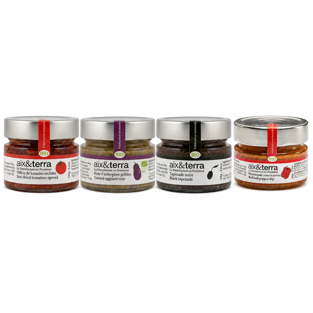 Sélection de tartinables bio Aix & Terra présentée en pots en verre, comprenant une crème de tomates séchées, un caviar d’aubergines grillées, une tapenade noire et une poivronnade au poivron rouge.