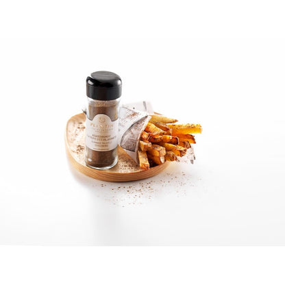 Flacon d’assaisonnement à la truffe d’été Plantin présenté aux côtés de frites dorées servies dans un cornet en papier. Le produit est disposé sur un plateau en bois avec un léger saupoudrage d’assaisonnement, dans une mise en scène gourmande et épurée sur fond clair.