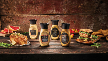 Sélection de sauces et condiments Maille comprenant mayonnaise fine, mayonnaise à l'ancienne, moutarde de Dijon et moutarde au miel, présentée dans une ambiance gourmande avec sandwichs et tartines.